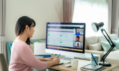 woman working from home on desk with large screen