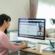 woman working from home on desk with large screen