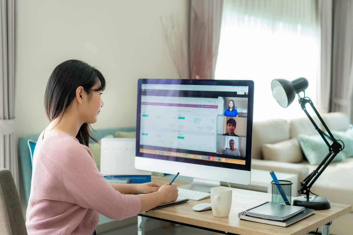 woman working from home on desk with large screen